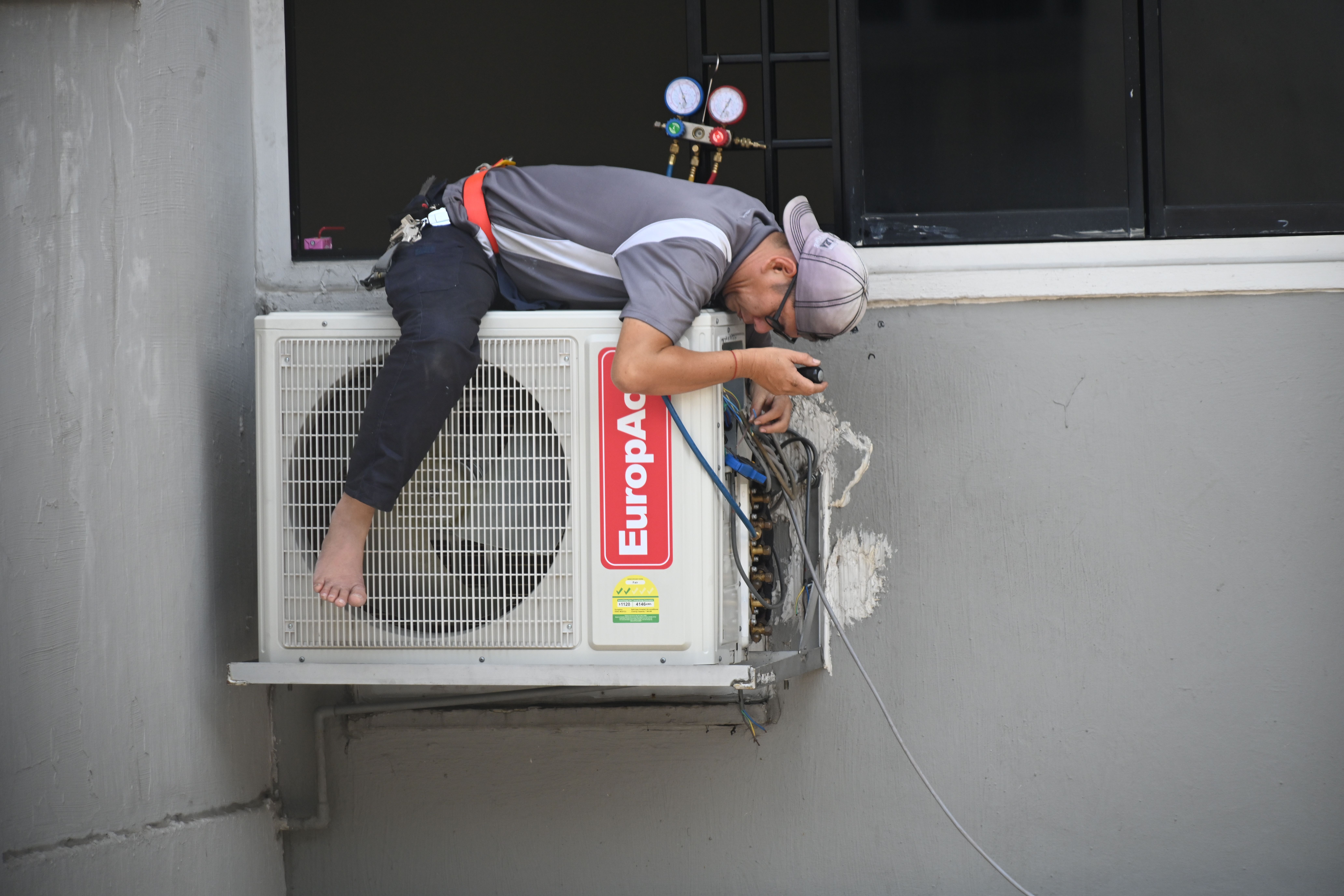 Installer working on a half-fitted outdoor unit